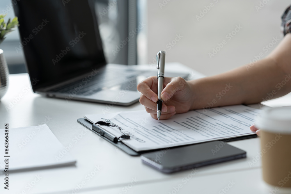 Businesswoman, office worker working using laptop and mobile phone in real estate accounting analysis reporting, discussing agreement contract documents financial and tax system concepts. Businesswoman, office worker working using laptop and mobile phone in real estate accounting analysis reporting, discussing agreement contract documents financial and tax system concepts.