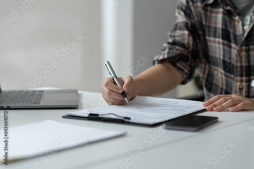 Businesswoman, office worker working using laptop and mobile phone in real estate accounting analysis reporting, discussing agreement contract documents financial and tax system concepts.