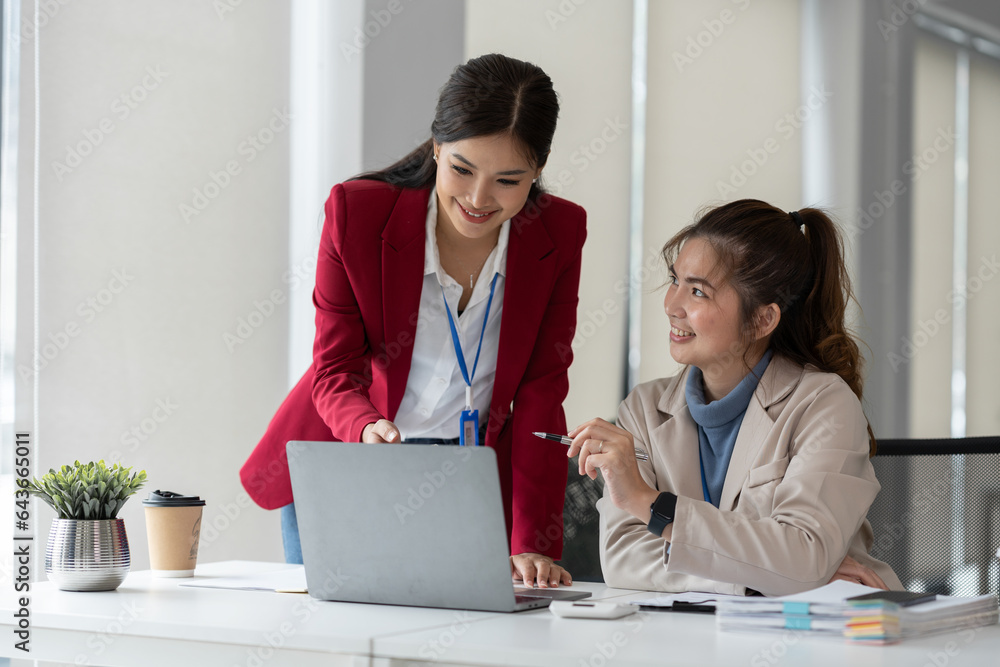 Two Asian businesswomen discuss working on a new project idea presentation. Calculate marketing plans and investments real estate tax office Two Asian businesswomen discuss working on a new project idea presentation. Calculate marketing plans and investments real estate tax office