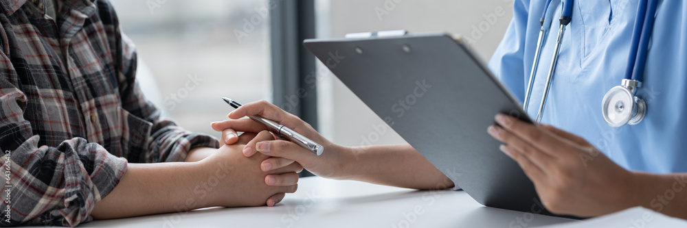 Asian female doctor using a stethoscope to examine a patient, ask for information, give advice, comfort, plan a course of treatment and preventive care. concept of health check Asian female doctor using a stethoscope to examine a patient, ask for information, give advice, comfort, plan a course of treatment and preventive care. concept of health check