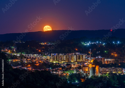 Cityscape of the city of Morgantown in WV as supermoon rises over the town and West Virginia downtown university apartments