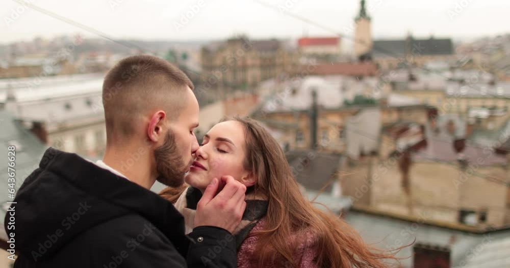 Kisses and hugs of a young couple in love. A romantic meeting of a young couple in the city center on a gloomy autumn day. Happy boy and girl hug, kiss, enjoying time together. Kisses and hugs of a young couple in love. A romantic meeting of a young couple in the city center on a gloomy autumn day. Happy boy and girl hug, kiss, enjoying time together.