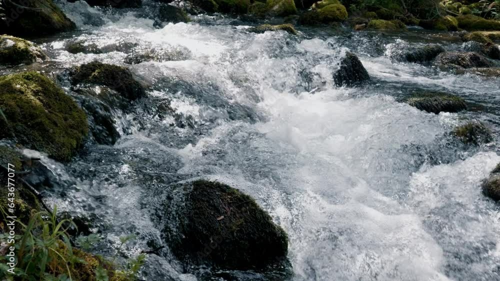 Water flowing fast in mountain river slow motion closeup shot Water flowing fast in mountain river slow motion closeup shot