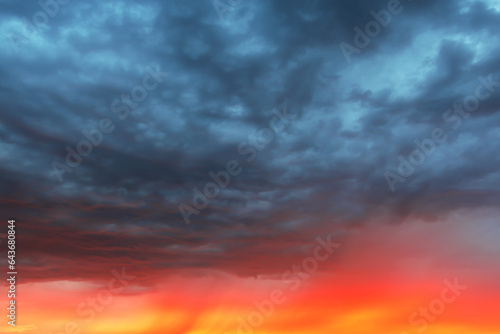 Dramatic sky at sunset, dangerous heavy gray red color clouds in sky, abstract sky and nature background