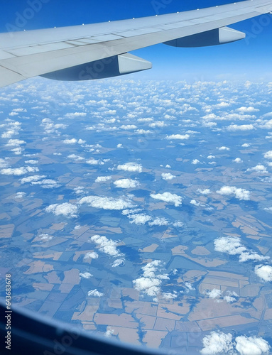 Beautiful view from above to the ground from the window of an airplane flying above the clouds. Shadows from clouds on the Earth's surface