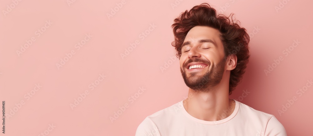 Obraz premium Happy man with hands behind head smiling on pink background