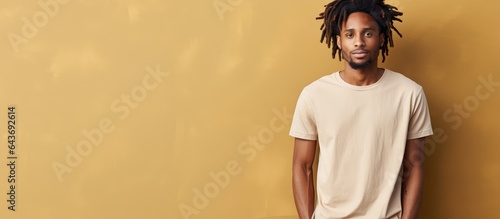 Young African man with dreadlocks in a casual t shirt on a blank backdrop