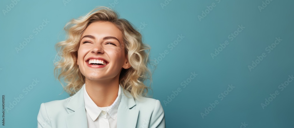 A happy blonde woman in an office jacket standing on a blue background with room for text A happy blonde woman in an office jacket standing on a blue background with room for text