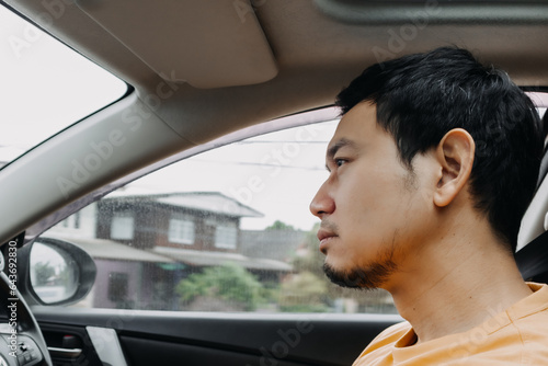 Portrait of asian man sleepy boring while driving a car.