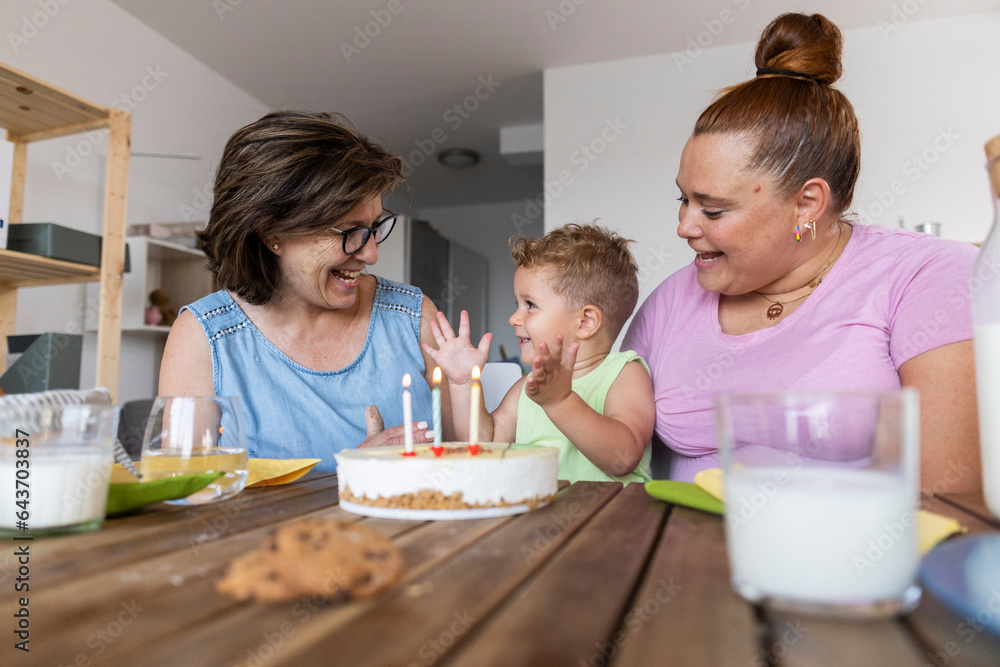 happy family of mother and grandmother and little boy celebrating birthday. multigeneration people in the living room of their house happy family of mother and grandmother and little boy celebrating birthday. multigeneration people in the living room of their house