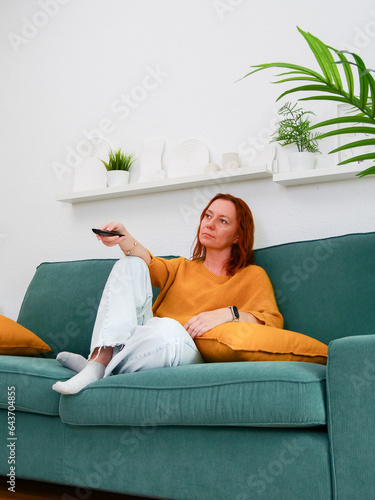 procrastination. Woman sitting on sofa and holding remote control. leisure and leisure activity. TV watch. watching series