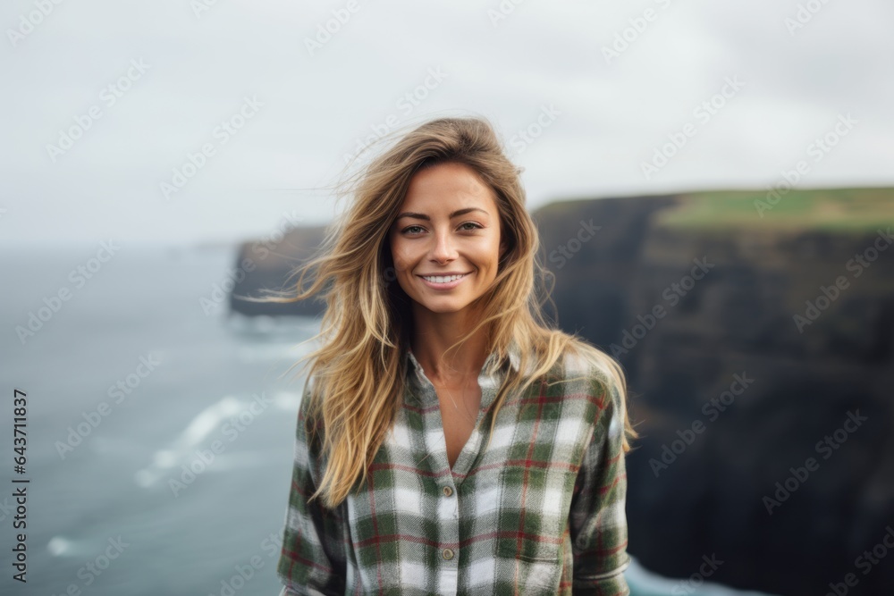 Environmental portrait photography of a joyful girl in her 20s wearing a relaxed flannel shirt at the cliffs of moher in county clare ireland. With generative AI technology