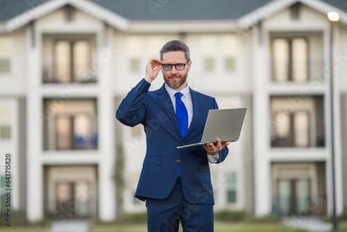 Serious hispanic man working on laptop. Businessman checking email on laptop, writing message in social network, using internet, searching information on laptops. Business man using laptop.