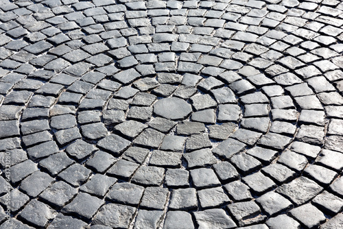 Stone pavement in perspective, texture of cobblestone road, gray cobbled road background.