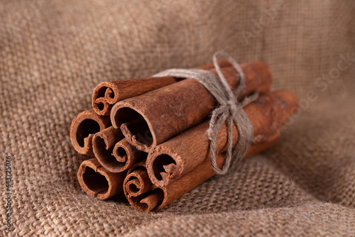 cinnamon sticks tied with twine on a coarse cloth