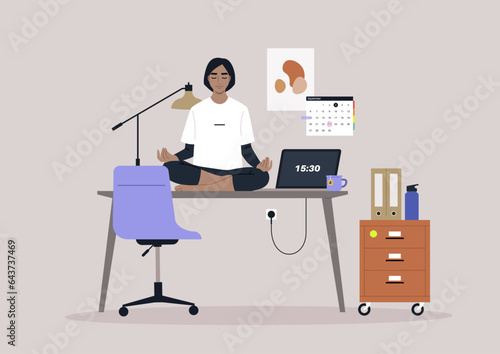 A young manager meditating on their desk in the workplace, using a mindful approach to reduce stress levels