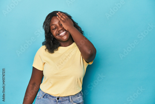 Young african american curvy woman laughing happy, carefree, natural emotion.