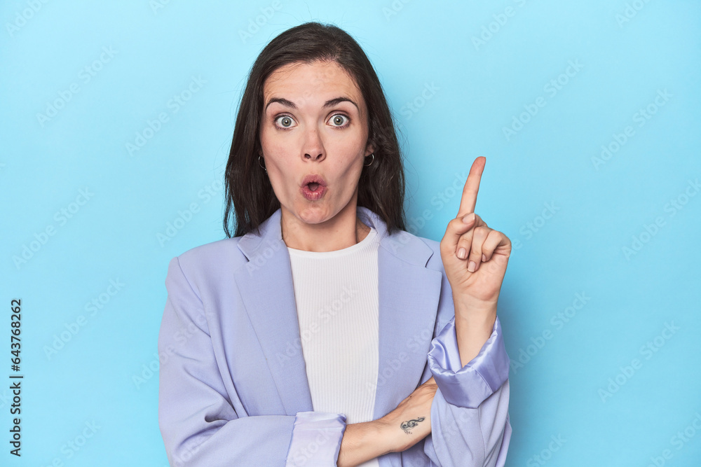 Woman in blue blazer on blue background having some great idea, concept of creativity. Woman in blue blazer on blue background having some great idea, concept of creativity.