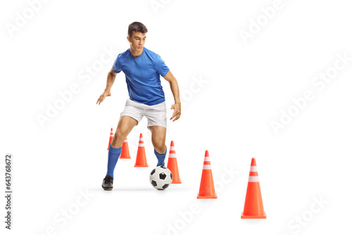 Football player running and leading a ball through training cones