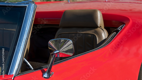 detail of the mirror of the seat, Aitgo red car with chrome details and two-tone black and white tire.
