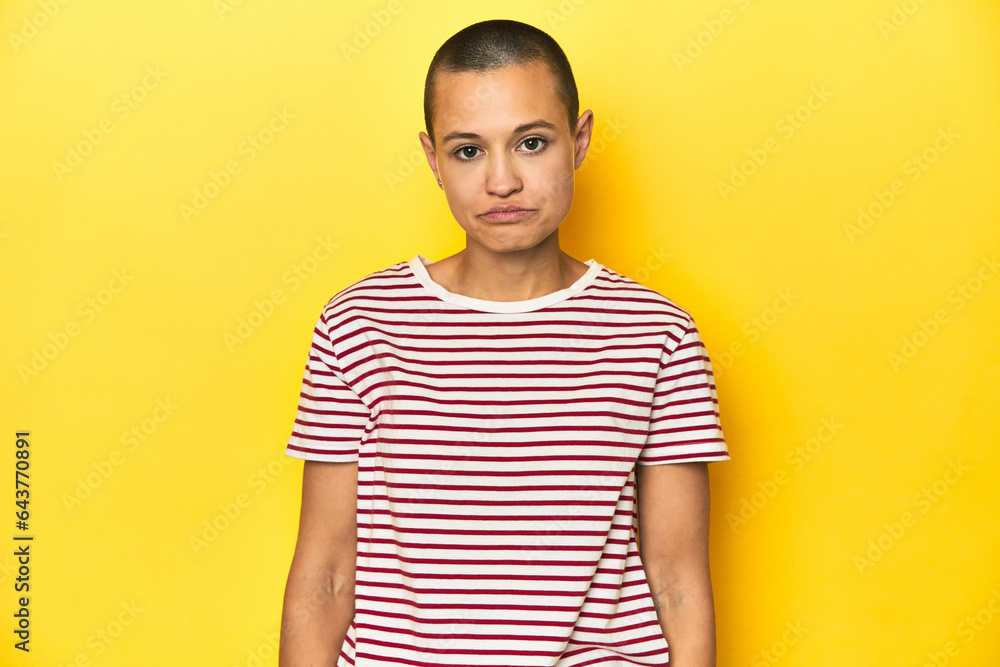 Shaved head woman in red striped tee, yellow backdrop sad, serious face, feeling miserable and displeased. Shaved head woman in red striped tee, yellow backdrop sad, serious face, feeling miserable and displeased.