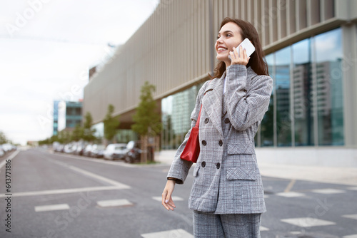 Employee lady talking on smartphone walking having conversation outdoor