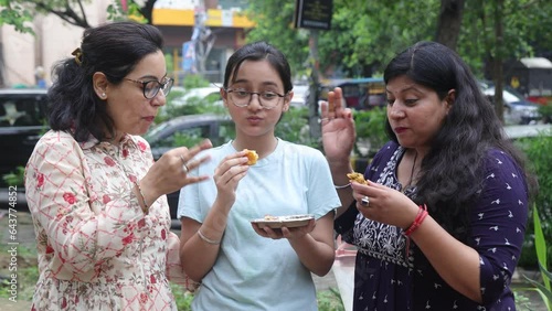 Girls eating pakora. Indian Girls having Indian street food like pakoras. Cool Mid aged Girls having Indian street food like pakoras