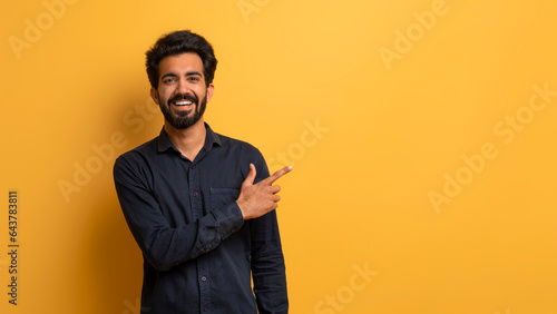 Handsome Young Indian Man Pointing Aside At Copy Space With Hand © Prostock-studio