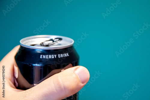 a close up of a hand holding a can of energy drink