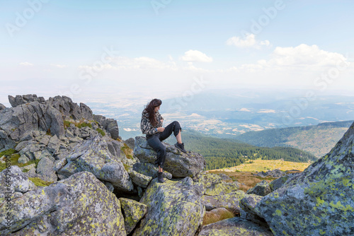 Woman sitting high in the  summer mountain with stunning view  © boryanam
