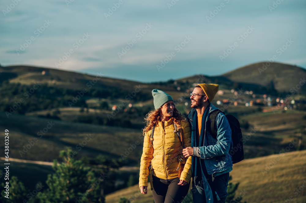 Couple of hikers walking on a mountain trail during a vacation