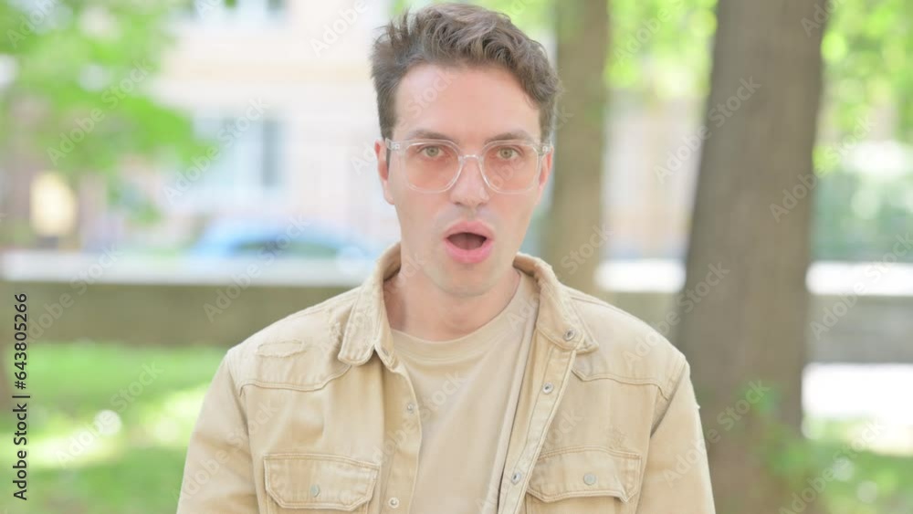 Outdoor Portrait of Shocked Casual Young Man in Awe Outdoor Portrait of Shocked Casual Young Man in Awe