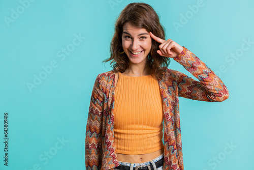 You are crazy, out of mind. Displeased woman pointing at camera, show stupid gesture finger near head, blaming some idiot for dumb insane plan idea, senseless talk. Girl isolated on blue background