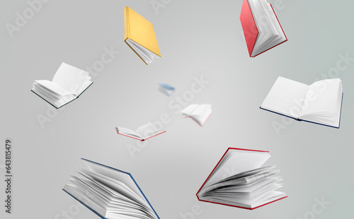 Many flying books on grey b...