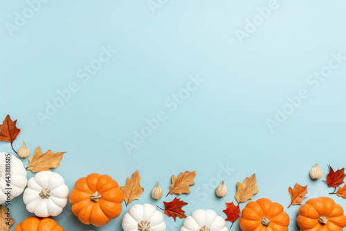 White and orange decorative pumpkins top view on blue background with copy space