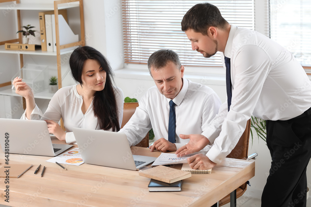 Business consultants working at table in office Business consultants working at table in office