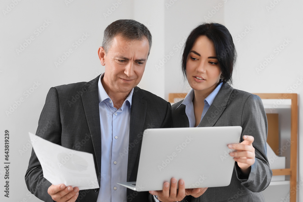 Business consultants working with laptop in office Business consultants working with laptop in office