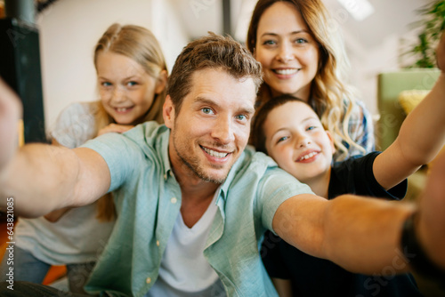 Portrait of a young Caucasian family looking at the camera in the living room