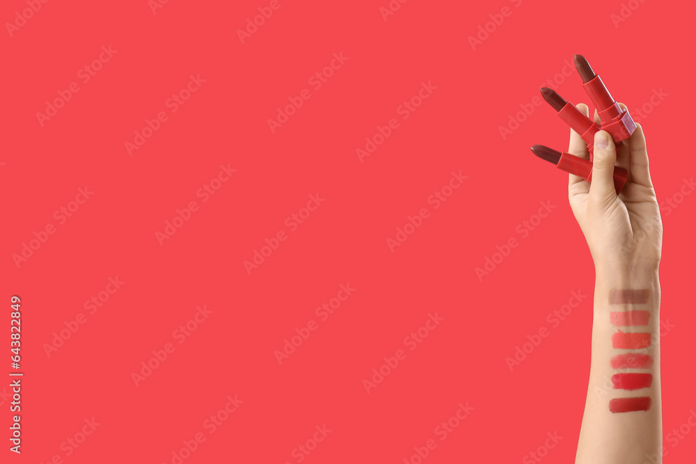 Woman with lipsticks and samples on red background Woman with lipsticks and samples on red background