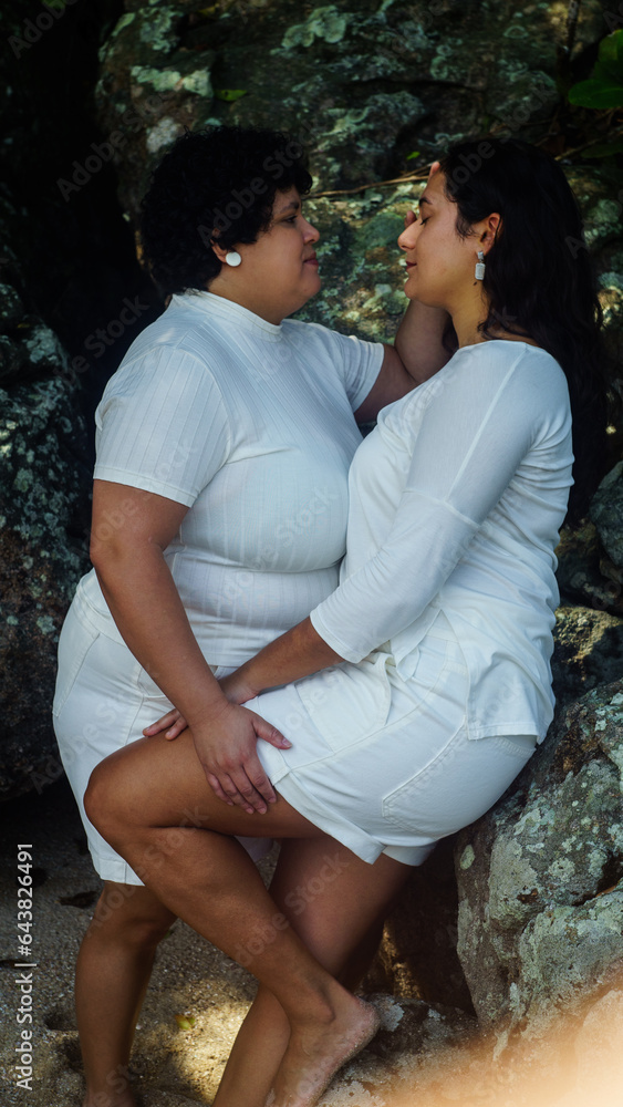 Naklejka premium couple of lesbian women on the beach, dressed in white, lgbtqia+ representation, love between women