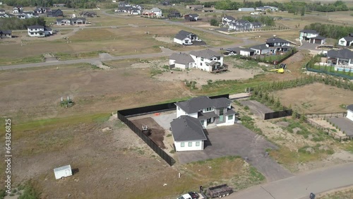 Aerial footage of Edgemont Estates, Saskatoon, SK, showcasing its upscale homes, manicured landscapes, and community design. A pristine suburban enclave, perfect for real estate showcases. photo