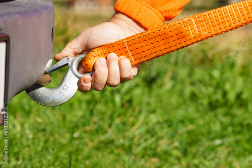 Male hand attaching towline to car