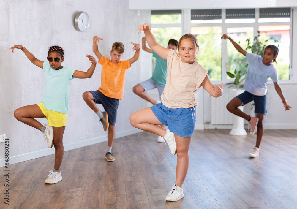 Obraz premium Portrait of smiling children practicing sport dance in modern dance hall