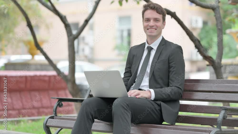 Businessman Smiling at Camera with Laptop in Lap Outdoor Businessman Smiling at Camera with Laptop in Lap Outdoor