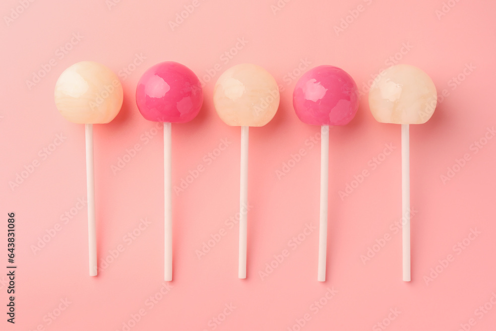 Tasty lollipops on pink background, flat lay Tasty lollipops on pink background, flat lay