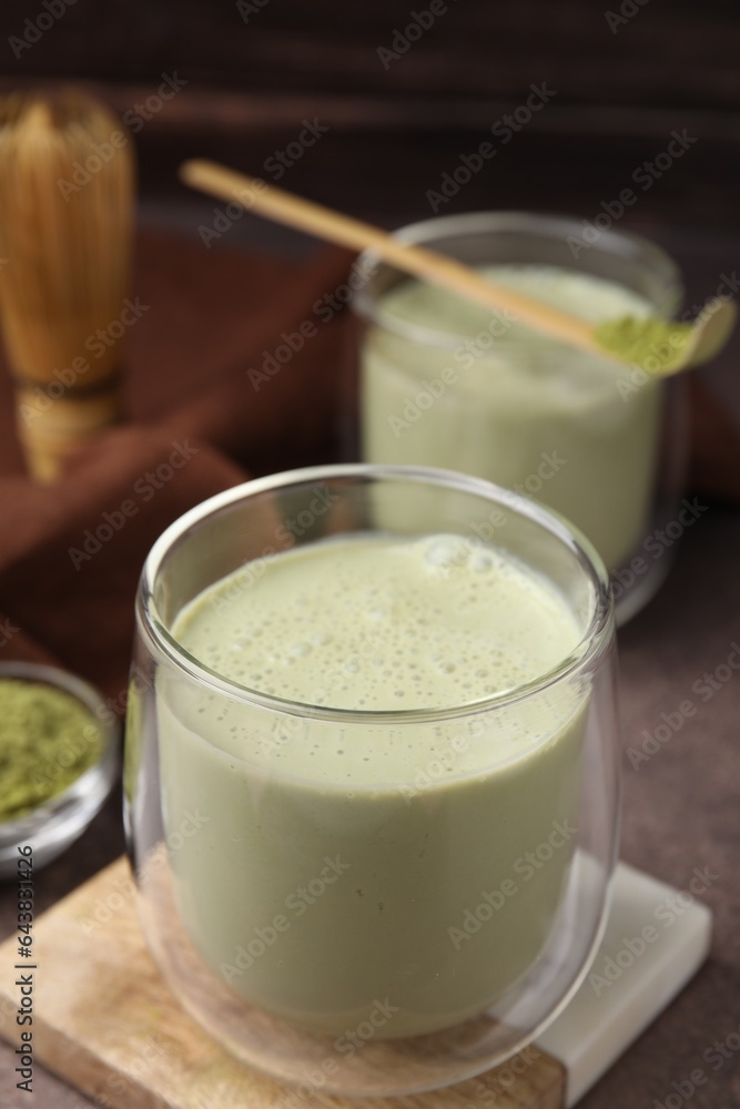 Glass of tasty matcha smoothie on brown table, closeup. Space for text Glass of tasty matcha smoothie on brown table, closeup. Space for text