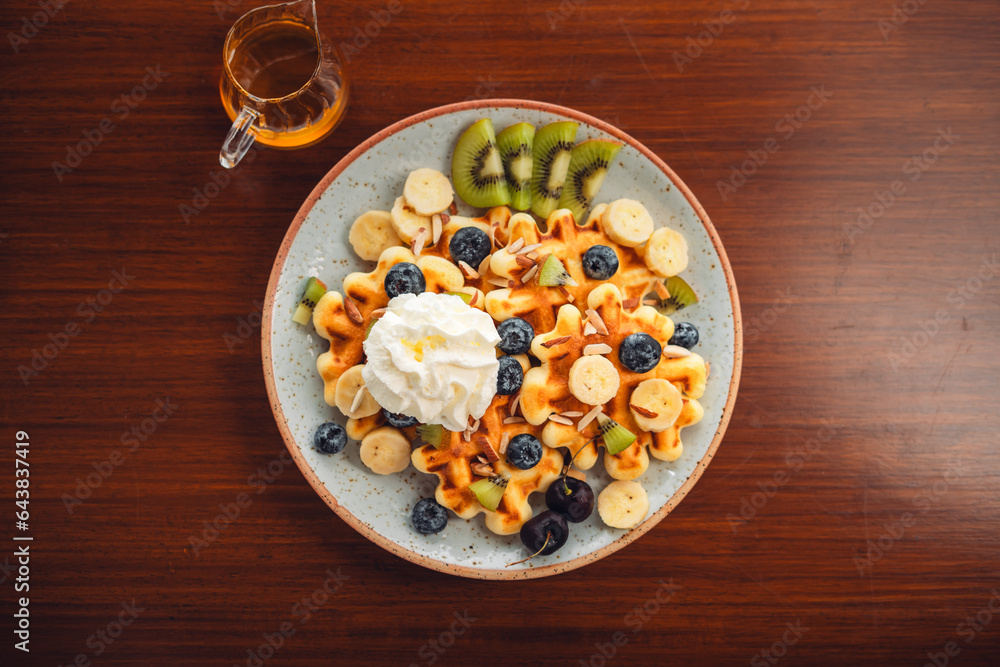 Waffles with mixed fruit, cream topping and honey Waffles with mixed fruit, cream topping and honey