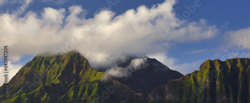 A panorama of the Ko'olau mountain range from the windward side of Oahu, Hawaii at the sun rises and illuminates the mountain