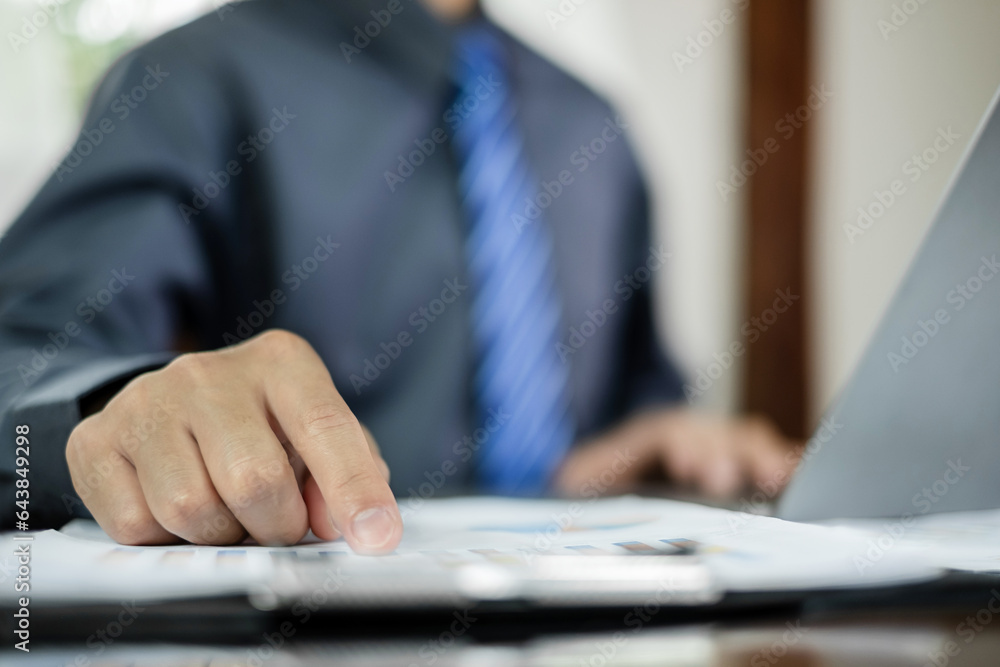 The business hand sits at their desks and calculates financial graphs showing the results of their investments planning the process of successful business growth The business hand sits at their desks and calculates financial graphs showing the results of their investments planning the process of successful business growth