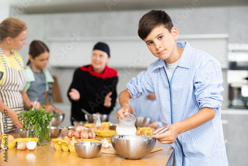 Boy learns how to cook dish at cooking master class